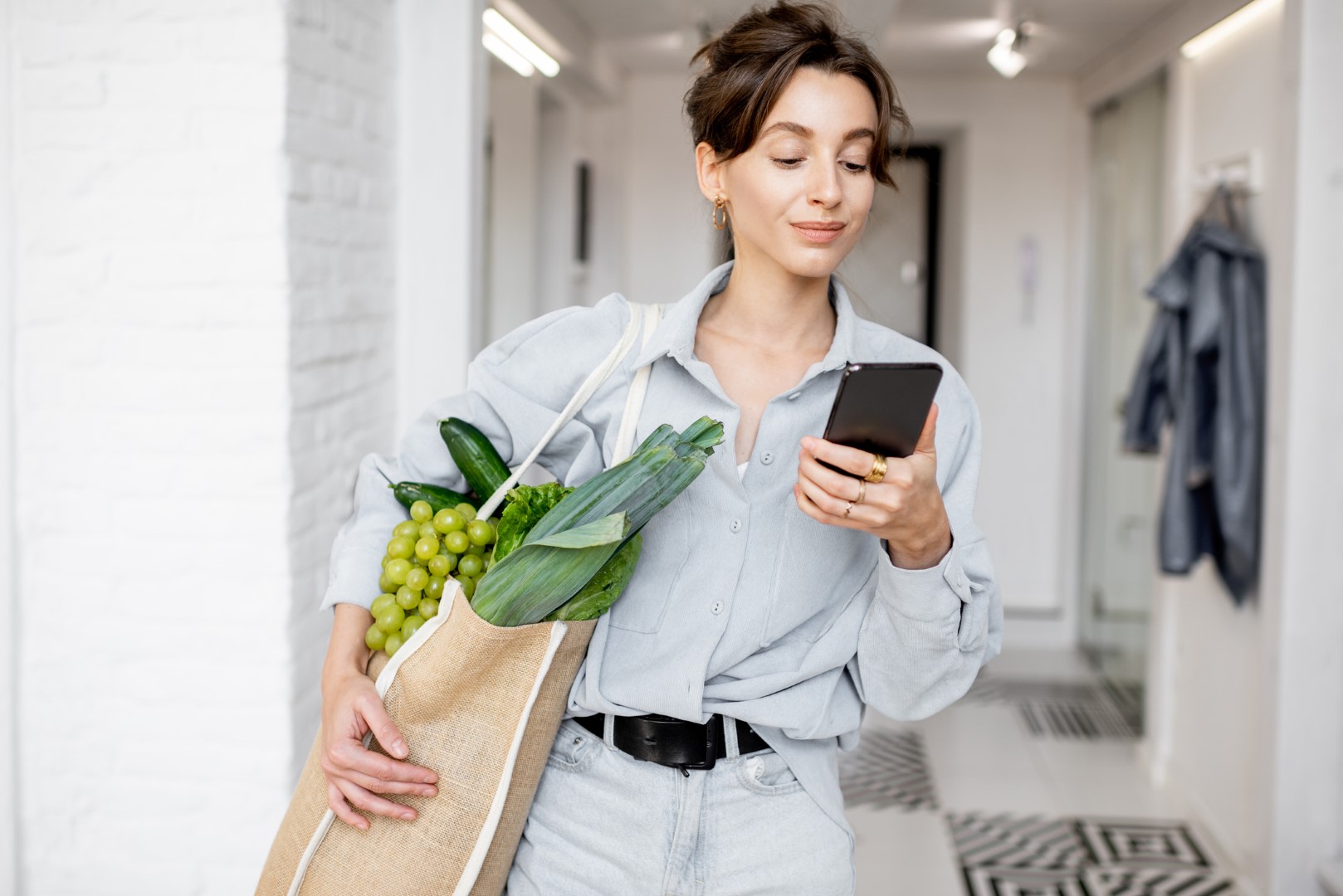 Прийти домашний. Woman standing with Phone. Woman comes Home.